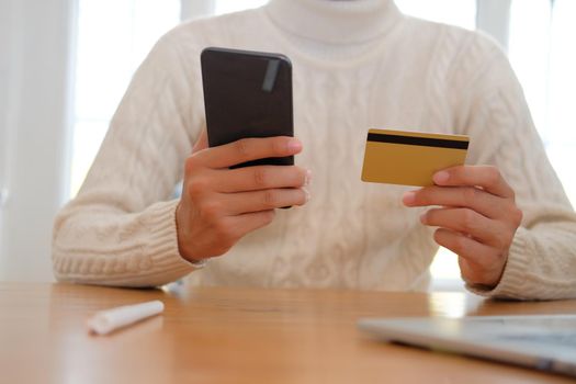 man holding credit card & smart phone for online shopping.  male buyer buying or make payment on internet.