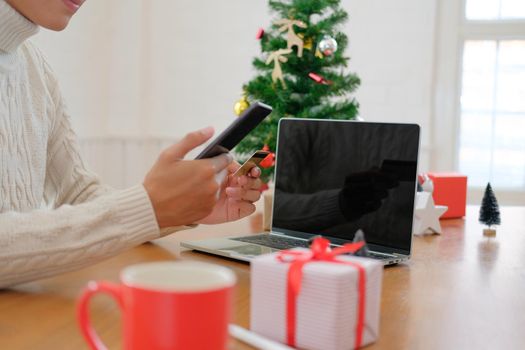 man holding credit card & smart phone for online shopping.  male buyer buying christmas gift on internet. merry xmas new year holiday celebration