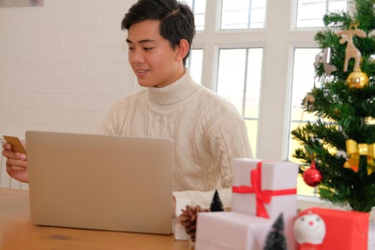 man holding credit card for online shopping. male buyer buying christmas gift on internet. new year holiday merry xmas celebration