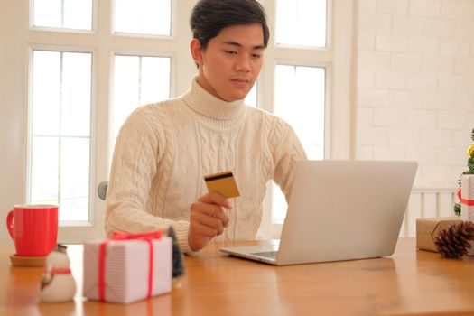 man holding credit card for online shopping. male buyer buying christmas gift on internet. new year holiday merry xmas celebration