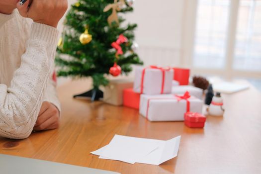 man wearing cream sweater thinking with pensive expression. christmas decoration at xmas new year holiday celebration.