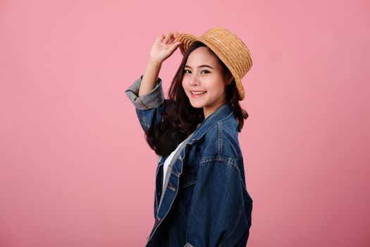 portrait of smiling young asian woman wearing jeans jacket.  studio shot