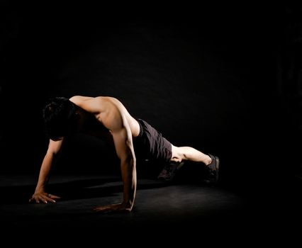 portrait of athletic muscular bodybuilder man with naked torso doing push ups exercise. fitness workout concept