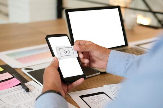user experience UX designer designing web on smart phone layout. UI planning mobile application. developer work with business prototype