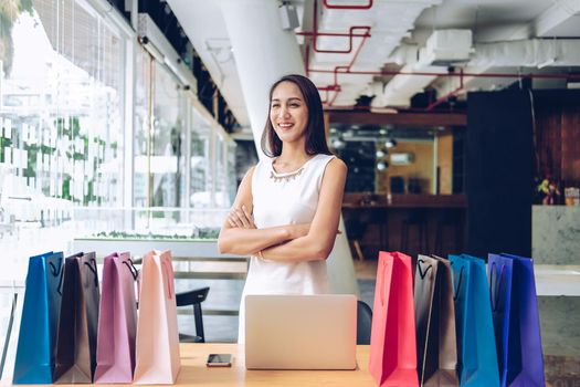 woman with colorful shopping bags on table. consumerism lifestyle concept