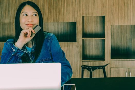 woman holding credit card using computer for shopping online