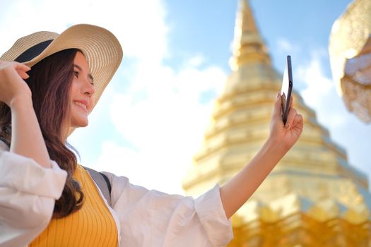 asian woman use smart phone to take selfie photo. traveler tourist travel on holiday vacation. journey trip concept