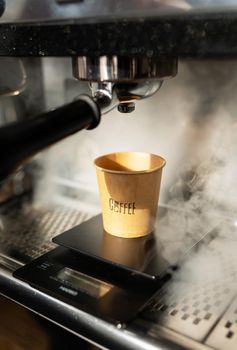 Disposable paper cup, coffee preparation, cooking process, hot steam. Barista work. The concept of cooking coffee, coffee to go