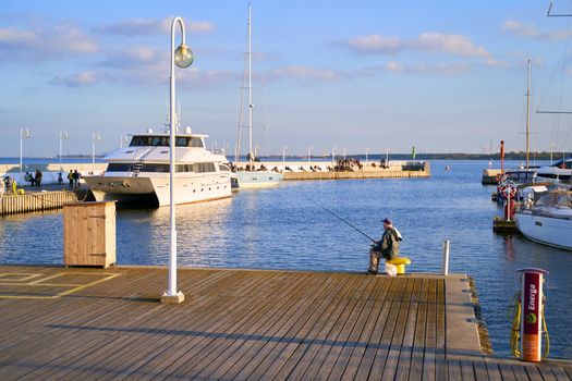 Old man fishing with a rod at the Sopot Pier aka Molo