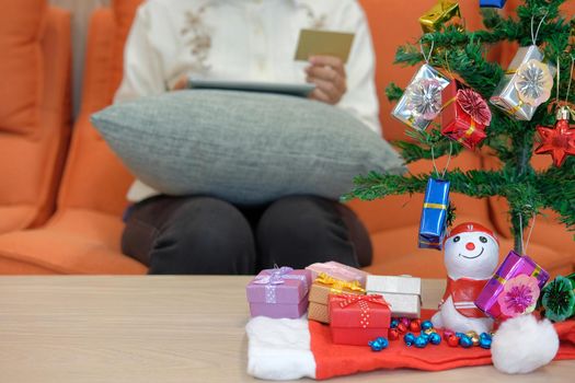 woman holding credit card & tablet for online shopping.  female buyer buying christmas gift on internet. new year holiday merry xmas celebration