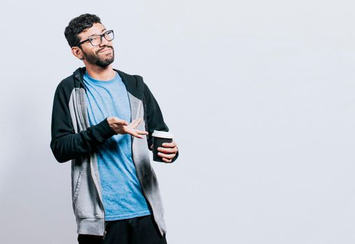 Smiling person with coffee on isolated background, guy pointing disposable cup of coffee on isolated background, concept of a man showing looking at disposable cup of coffee