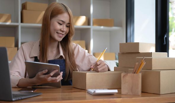 Startup successful small business owner sme beauty girl stand with tablet smartphone in coffee shop restaurant. Portrait of asian tan woman barista cafe owner. SME entrepreneur seller business concept.