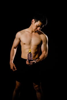 portrait of athletic muscular bodybuilder man with naked torso six pack abs holding water bottle. fitness workout concept