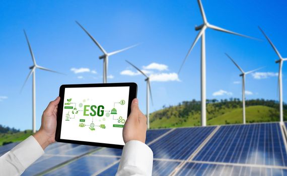 Green business transformation for environment saving and ESG business concept. Businessman using tablet to set corporate goal toward environmental friendly management and alternative clean energy use.