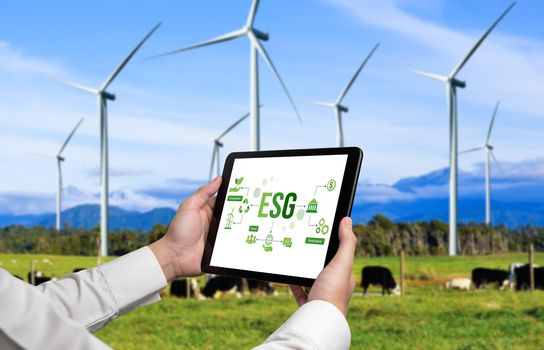 Green business transformation for environment saving and ESG business concept. Businessman using tablet to set corporate goal toward environmental friendly management and alternative clean energy use.