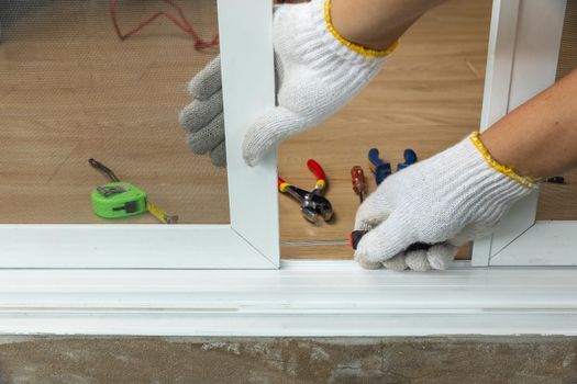 Worker fixing the insect screen sliding door