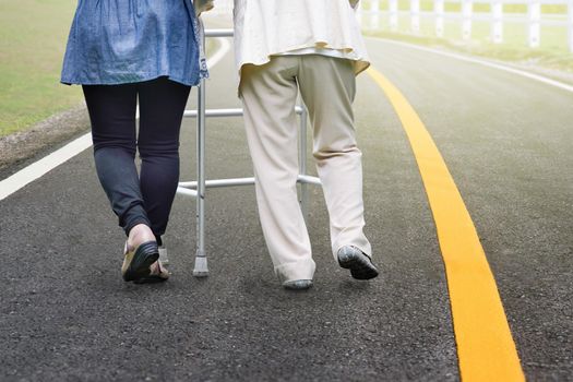 Elderly woman exercise walking in road with daughter