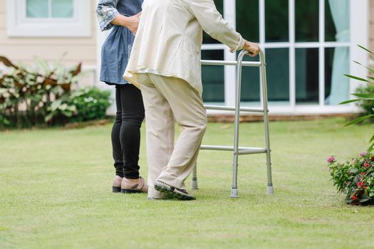 Elderly woman exercise walking in backyard with daughter