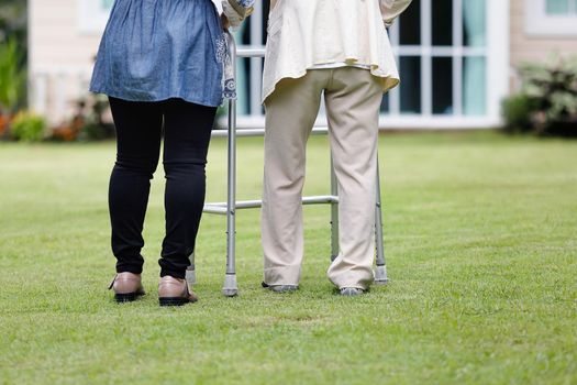 Elderly woman exercise walking in backyard with daughter