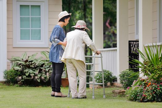 Elderly woman exercise walking in backyard with daughter