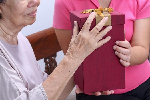 Elderly woman receiving a gift from daughter