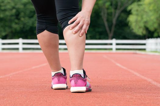 Middle aged woman runner muscle pain during training outdoors