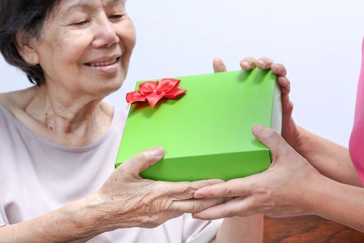 Elderly woman receiving a gift from daughter