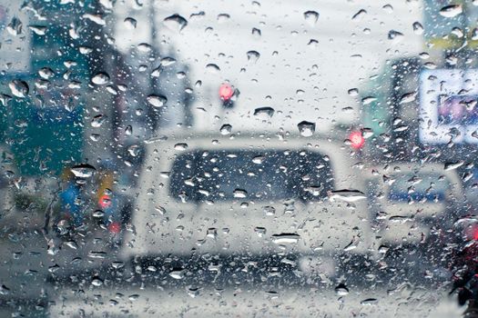 Raindrops on windshield from inside the car in traffic jam