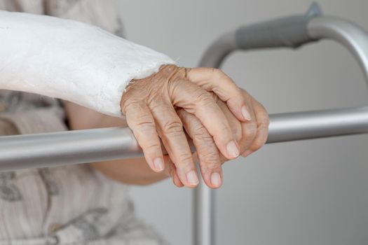 Senior woman with broken arm using the toilet with walker.