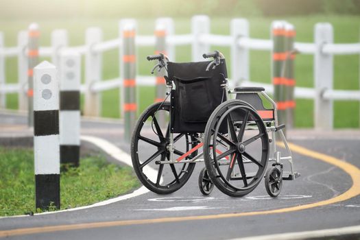 Empty wheelchair across the road in park