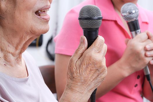 Elderly woman sing a song with daughter at home.