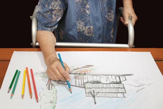 Elderly woman painting color on her drawing with walker , hobby at home.