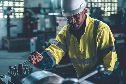 Factory worker or engineer do machine job in adept manufacturing workshop . Industrial people and manufacturing labor concept .