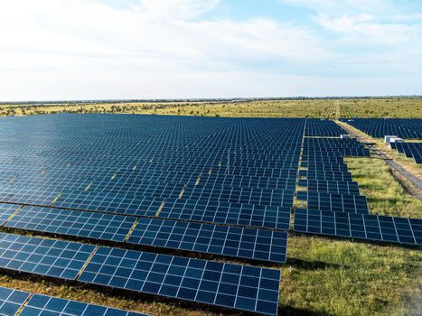 Aerial top view of a solar panels power plant. Photovoltaic solar panels at sunrise and sunset in countryside from above. Modern technology, climate care, earth saving, renewable energy concept