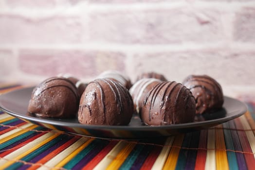 dark chocolate on a plate on pink background .