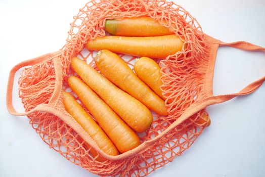 fresh carrots in shopping bag on white ,