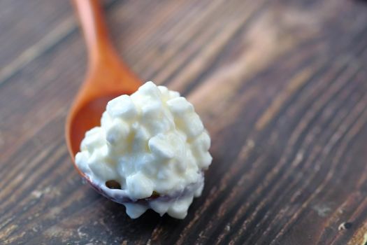 close up of cottage cheese on spoon on table