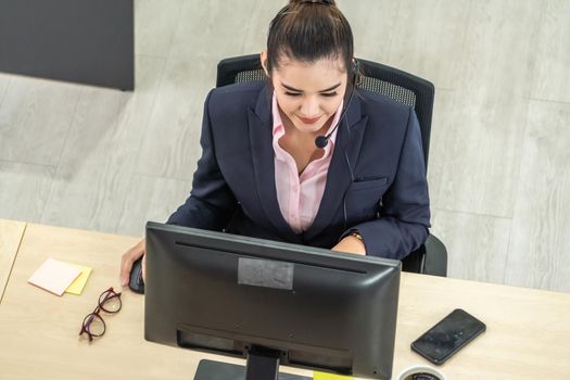 Business people wearing headset working in office to support remote customer or colleague. Call center, telemarketing, customer support agent provide service on telephone video conference call.