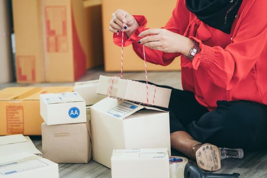 Online seller works at home office and packs shipping delivery box to customer. Small business owner or entrepreneur doing e-commerce business on the internet.