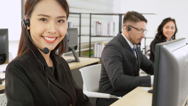 Business people wearing headset working in office to support remote customer or colleague. Call center, telemarketing, customer support agent provide service on telephone video conference call.