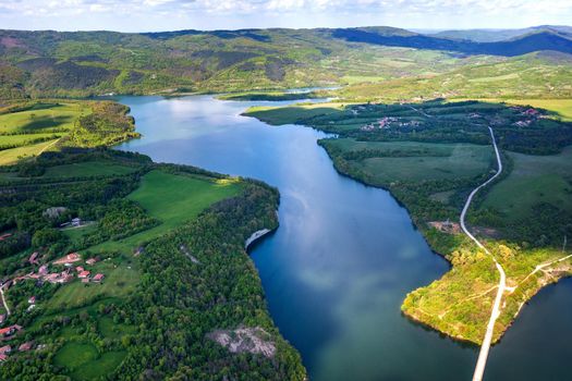 Spectacular aerial view from a drone to a lake and a road between hills. Yovkovtsi, Bulgaria