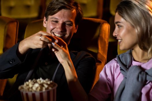 Caucasian lover enjoying to watch movie and eating popcorn together in the cinema