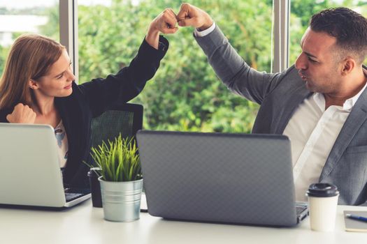 Success business partner - Businesswoman and businessman celebrating together in modern workplace office. People corporate teamwork concept.