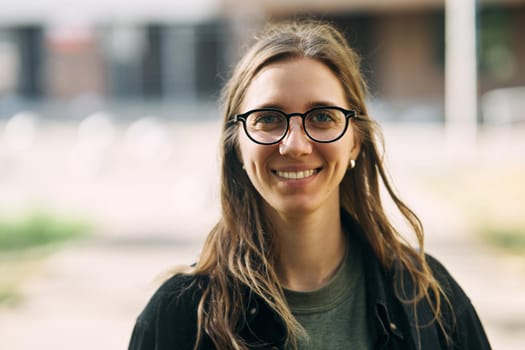 Portrait of a smiling young girl with glasses in the park. High-quality photo