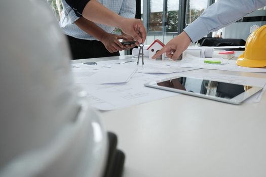 architect working on real estate project with partner at workplace. engineer discussing with colleague on living house blueprint at office. construction & building concept