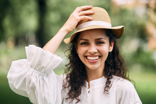 Young beautiful girl in a hat in a summer park. High quality photo