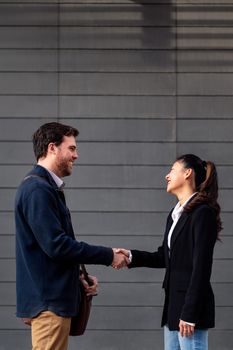 caucasian businessman and asiatic businesswoman shaking hands, concept of entrepreneurship and business, copy space for text