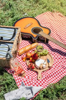 Closeup of picnic basket with drinks and food on the grass. Nice picnic on sunny summer day, fun and leisure