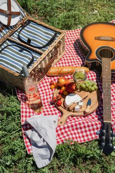 Closeup of picnic basket with drinks and food on the grass. Nice picnic on sunny summer day, fun and leisure