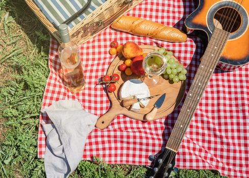 Closeup of picnic basket with drinks and food on the grass. Nice picnic on sunny summer day, fun and leisure